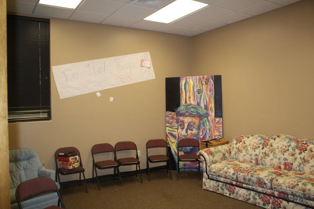 A room with a couch and chairs and a sign on the wall that says social justice