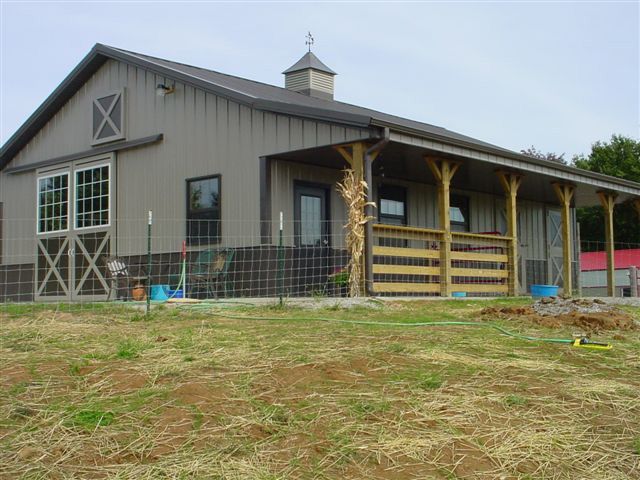 A barn with a porch and a fence around it
